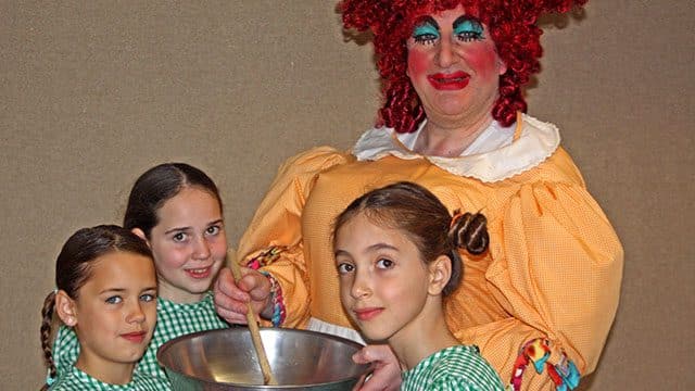 Richard Hunter as Dame Fanny the Cook with Tilda Fletcher,Savi Pachos and Isabel Tate.